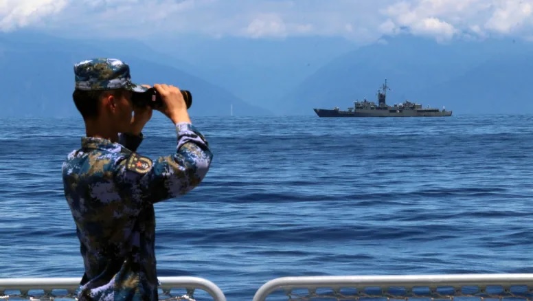 Seorang anggota tentara militer China meneropong kapal militer fregat Taiwan Lan Yang yang ada di dekatnya. China mengadakan latihan di perairan sekitar Taiwan sebagai tanggapan atas kunjungan Ketua DPR AS Nancy Pelosi baru-baru ini. Foto: Lin Jian/Xinhua/AP.