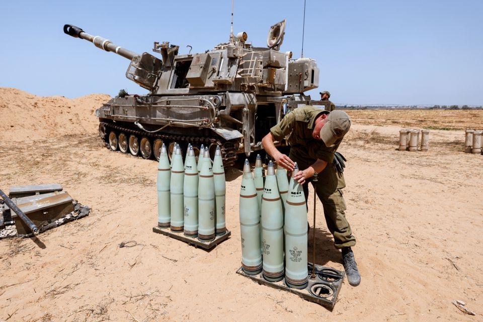 Seorang tentara Israel memeriksa amunisi di sebelah unit artileri bergerak di sebuah lapangan di sisi perbatasan Israel dengan Jalur Gaza 6 Agustus 2022. Foto: Reuters/Amir Cohen.