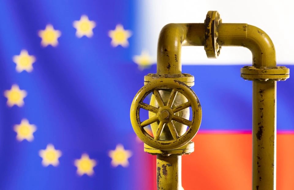 Pipa gas alam terlihat di depan tulisan warna bendera UE dan Rusia. Foto: Reuters.