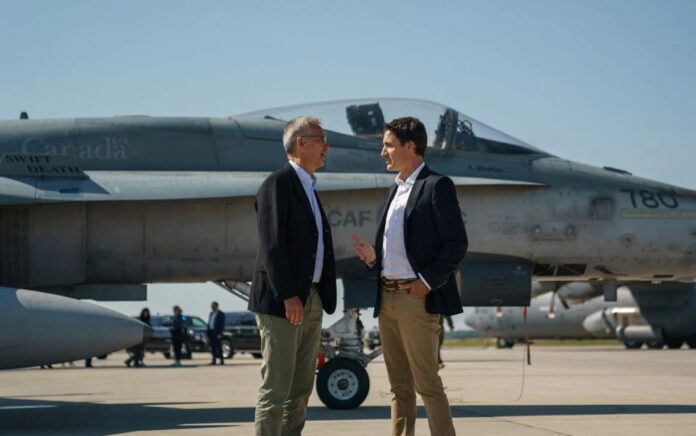 Perdana Menteri Kanada Justin Trudeau berbicara dengan Sekretaris Jenderal NATO Jens Stoltenberg di dekat pesawat tempur Angkatan Udara Kanada CF-18 Hornet selama kunjungan mereka ke CFB Cold Lake di Cold Lake, Alberta, Kanada 26 Agustus 2022. Foto: Adam Scotti/Kantor Perdana Menteri/Handout via Reuters.