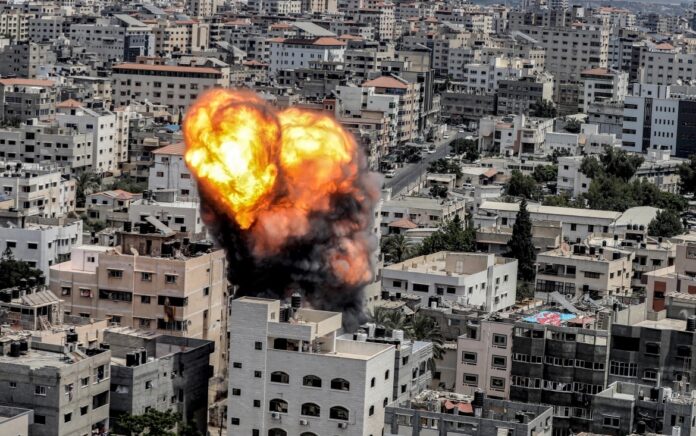 Sebuah bola api meletus sebagai akibat dari serangan udara Israel di sebuah bangunan di Kota Gaza. Foto: Ashraf Amra/AFP.