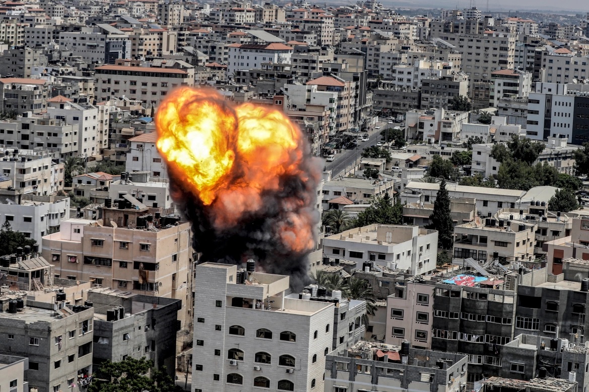 Sebuah bola api meletus sebagai akibat dari serangan udara Israel di sebuah bangunan di Kota Gaza. Foto: Ashraf Amra/AFP.