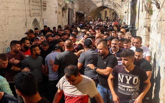 Tubuh Ibrahim Al-Nablusi digotong warga Palestina di sebuah rumah di Nablus di Tepi Barat menuju Rumah Sakit. Foto: Jaafar Ashtiyeh/AFP.