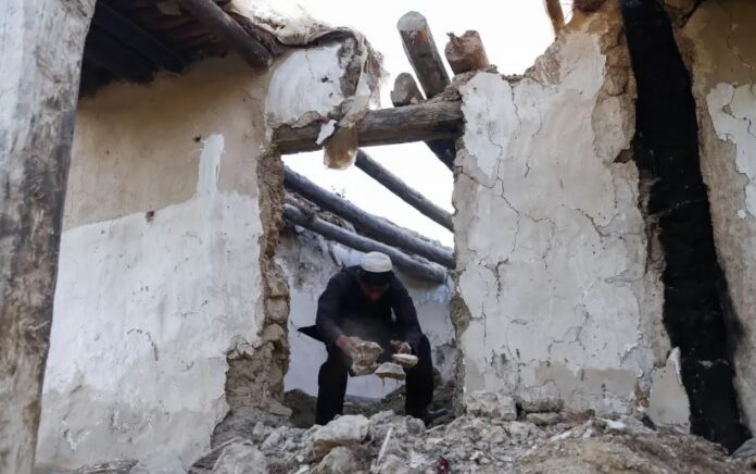 Seorang pria Afghanistan membersihkan puing-puing dari rumahnya yang rusak setelah gempa bumi baru-baru ini di desa Spolgin di distrik Spera provinsi Khost, Afghanistan, 26 Juni 2022. Foto: Reuters/Ali Khara.