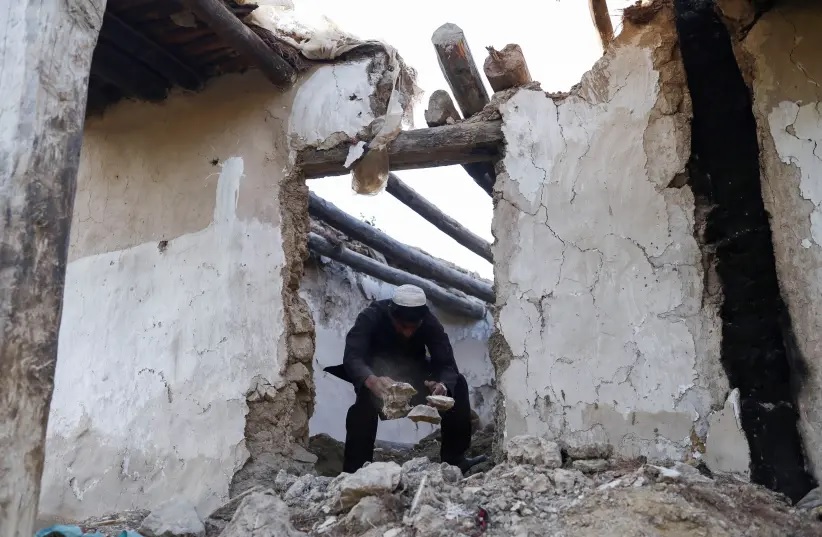 Seorang pria Afghanistan membersihkan puing-puing dari rumahnya yang rusak setelah gempa bumi baru-baru ini di desa Spolgin di distrik Spera provinsi Khost, Afghanistan, 26 Juni 2022. Foto: Reuters/Ali Khara.