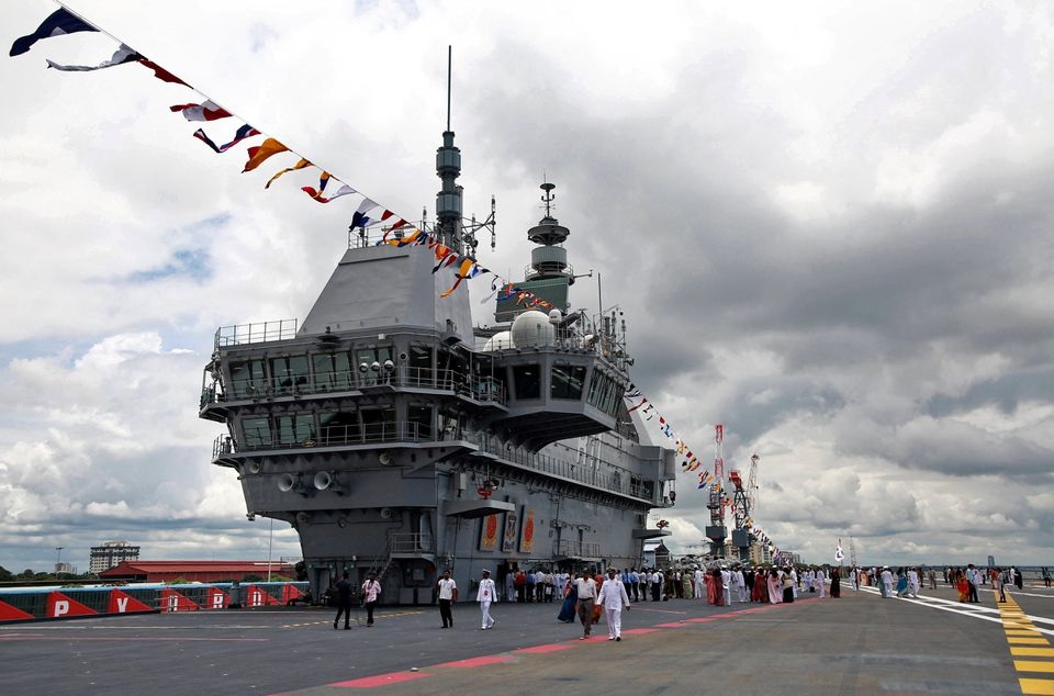 Perwira Angkatan Laut India dan awak media berjalan di dek penerbangan kapal induk buatan India pertama INS Vikrant setelah upacara peresmian di galangan kapal milik negara di Kochi, India, 2 September 2022. Foto: Reuters/Sivaram V.