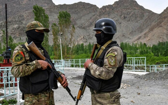 Dua tentara Kirgistan menjaga fasilitas pasokan air di luar desa KokTash dekat perbatasan Kirgistan-Tajikistan. Foto: Vladimir Voronin/AP.