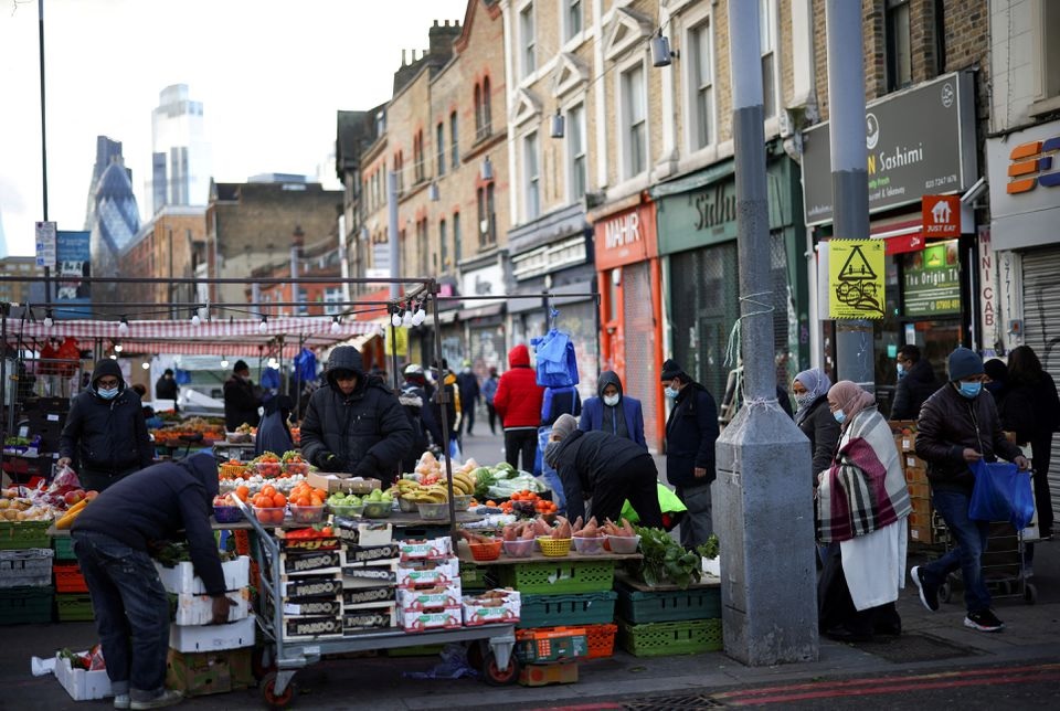 Orang-orang berbelanja di sebuah kios pasar di London timur, Inggris, 23 Januari 2021. Foto: Reuters/Henry Nicholls.