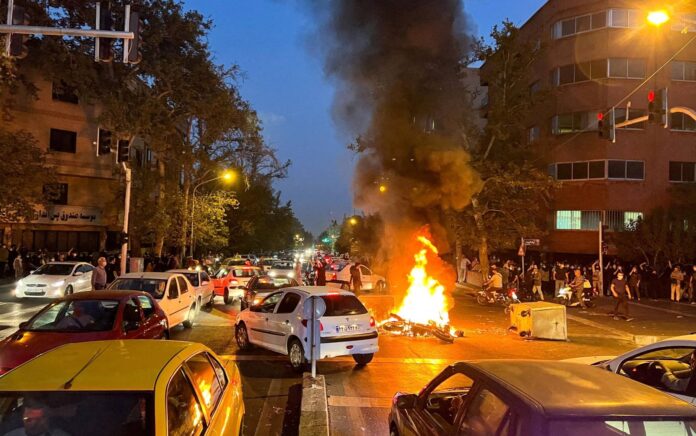 Sebuah sepeda motor polisi terbakar selama protes atas kematian Mahsa Amini, seorang wanita yang meninggal setelah ditangkap oleh "polisi moral" Republik Islam, di Teheran, Iran 19 September 2022. Foto: WANA/Reuters.