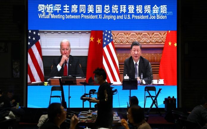 Sebuah layar menunjukkan Presiden China Xi Jinping menghadiri pertemuan virtual dengan Presiden AS Joe Biden melalui tautan video, di sebuah restoran di Beijing, China 16 November 2021. Foto: Reuters/Tingshu Wang.