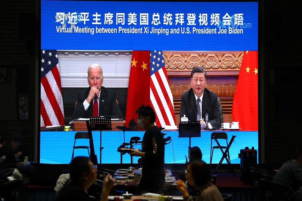 Sebuah layar menunjukkan Presiden China Xi Jinping menghadiri pertemuan virtual dengan Presiden AS Joe Biden melalui tautan video, di sebuah restoran di Beijing, China 16 November 2021. Foto: Reuters/Tingshu Wang.