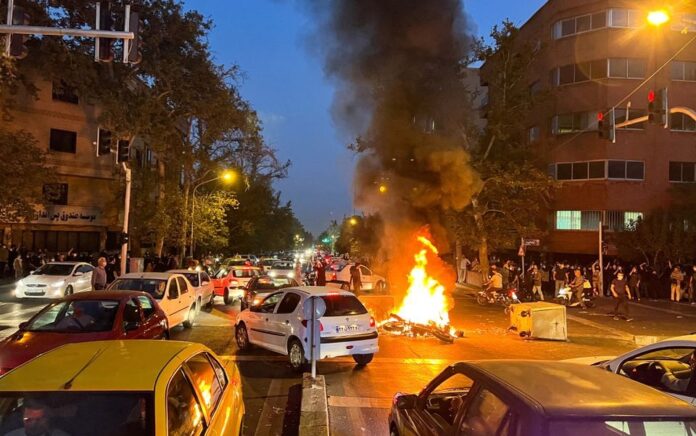 Sebuah sepeda motor polisi terbakar selama protes atas kematian Mahsa Amini, seorang wanita yang meninggal setelah ditangkap oleh "polisi moral" republik Islam itu, di Teheran, Iran 19 September 2022. Foto: WANA via Reuters.