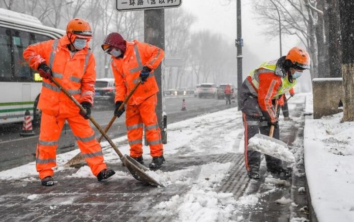 Sejumlah petugas kebersihan membersihkan salju di tepi jalan di Changchun, Provinsi Jilin, China timur laut, pada 12 November 2022. Hujan salju melanda beberapa wilayah di Provinsi Jilin pada Sabtu (12/11). Foto: Xinhua/Zhang Nan.