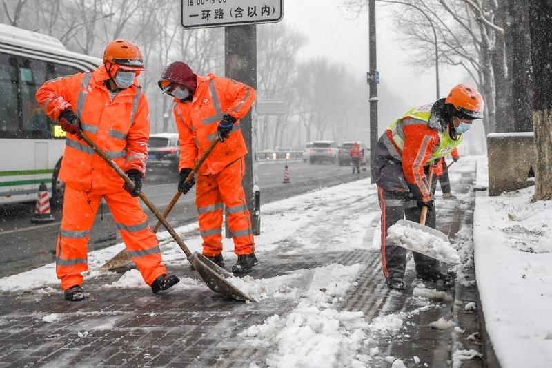 Sejumlah petugas kebersihan membersihkan salju di tepi jalan di Changchun, Provinsi Jilin, China timur laut, pada 12 November 2022. Hujan salju melanda beberapa wilayah di Provinsi Jilin pada Sabtu (12/11). Foto: Xinhua/Zhang Nan.