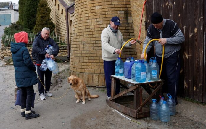 Orang mengisi botol dengan air di dekat sungai Dnipro setelah militer Rusia mundur dari Kherson, Ukraina 21 November 2022. Reuters/Murad Sezer.