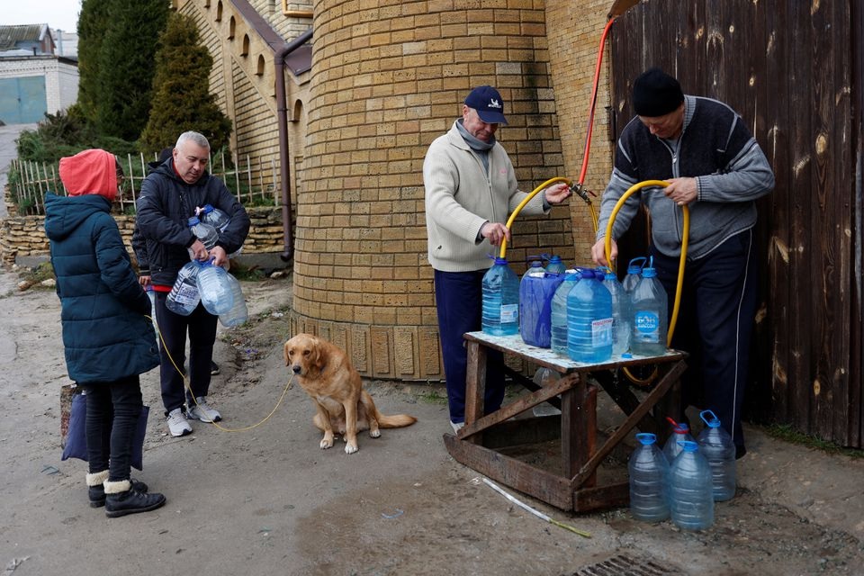 Orang mengisi botol dengan air di dekat sungai Dnipro setelah militer Rusia mundur dari Kherson, Ukraina 21 November 2022. Reuters/Murad Sezer.
