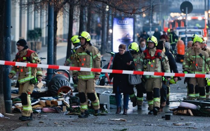 Layanan darurat bekerja di jalan di luar hotel setelah kebocoran akuarium AquaDom di pusat Berlin dekat Alexanderplatz, dengan air mengalir ke jalan, di Berlin, Jerman, 16 Desember 2022. Foto: Reuters/Michele Tantussi.