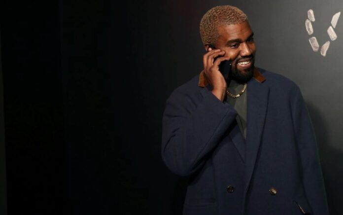 Rapper Kanye West berbicara di telepon sebelum menghadiri presentasi Versace di New York, AS, 2 Desember 2018. Foto: Reuters/Allison Joyce.