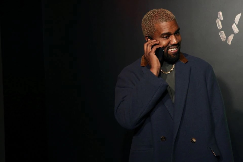 Rapper Kanye West berbicara di telepon sebelum menghadiri presentasi Versace di New York, AS, 2 Desember 2018. Foto: Reuters/Allison Joyce.