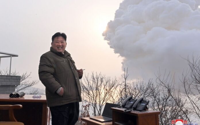 Pemimpin Korea Utara Kim Jong Un melihat uji coba bahan bakar padat baru sambil tangan kirinya memegang rokok. Foto: KCNA.
