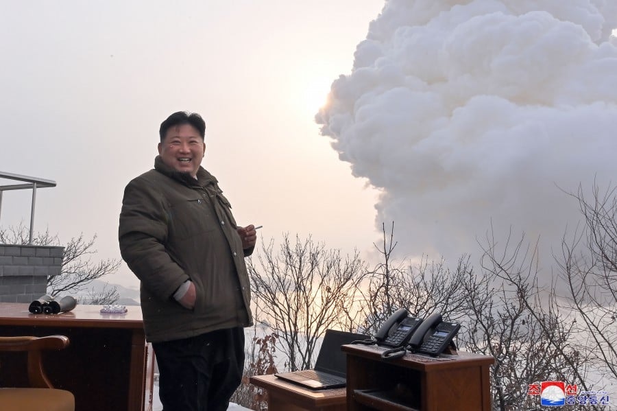 Pemimpin Korea Utara Kim Jong Un melihat uji coba bahan bakar padat baru sambil tangan kirinya memegang rokok. Foto: KCNA.