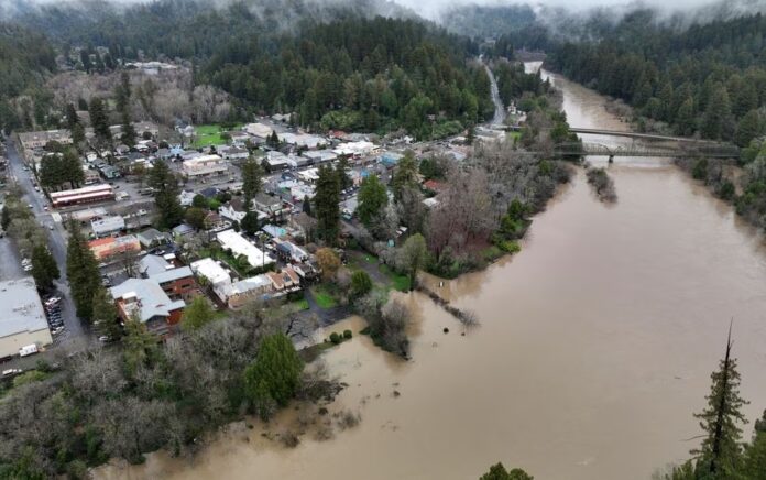 Sungai Rusia, meluap dengan air banjir setelah rangkaian badai musim dingin, mengalir melewati kota Guerneville, California, AS 15 Januari 2023. Foto: Reuters/Fred Greaves.