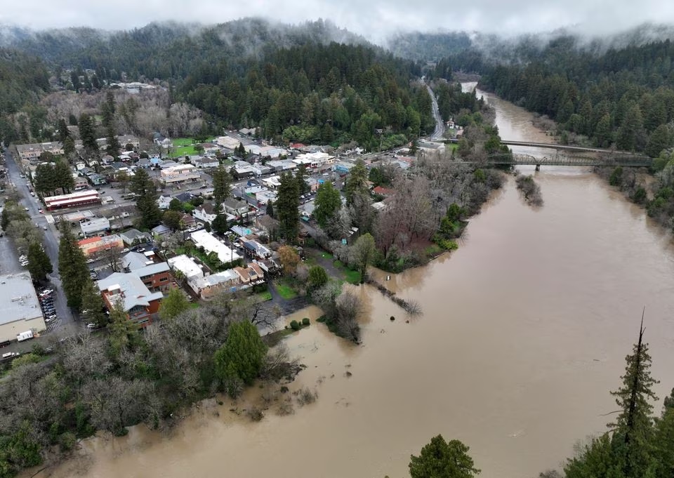 Sungai Rusia, meluap dengan air banjir setelah rangkaian badai musim dingin, mengalir melewati kota Guerneville, California, AS 15 Januari 2023. Foto: Reuters/Fred Greaves.