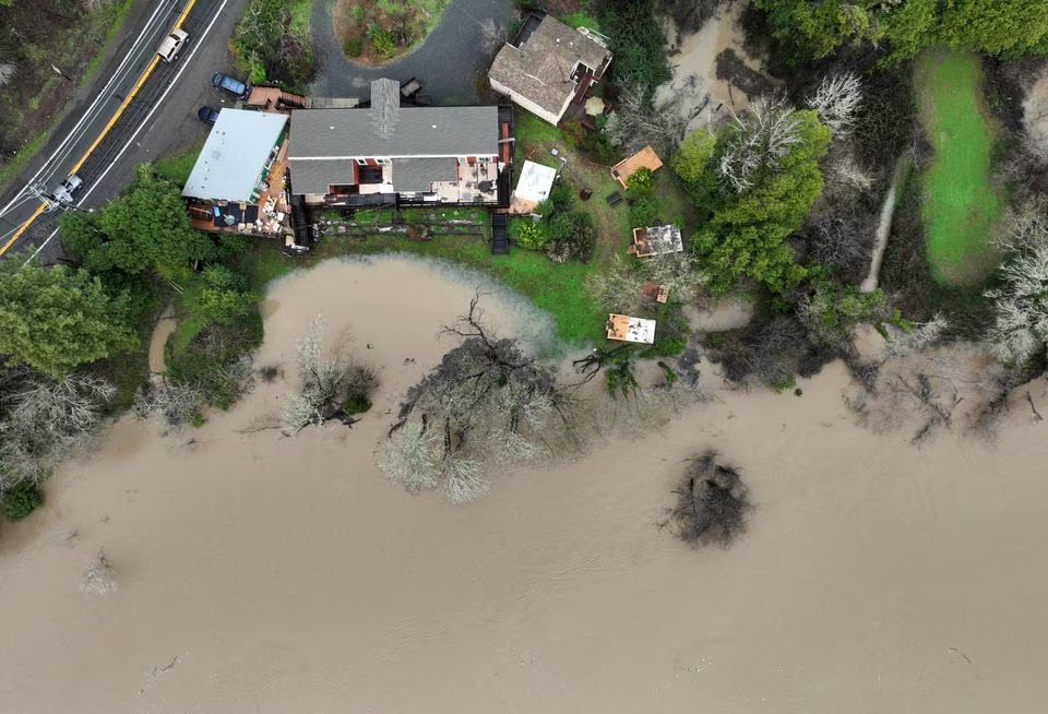 Air banjir dari Sungai Rusia mendekati rumah setelah rangkaian badai musim dingin, di Guerneville, California, AS 15 Januari 2023. Foto: Reuters/Fred Greaves.