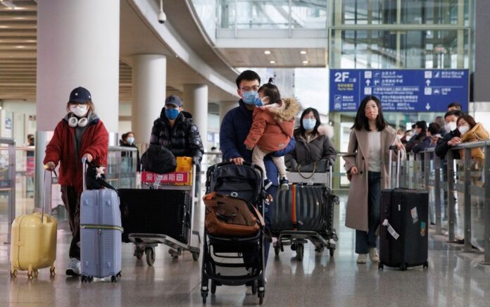 Penumpang mendorong bagasi mereka melalui aula kedatangan internasional di Bandara Internasional Ibukota Beijing setelah China mencabut persyaratan karantina penyakit virus corona (COVID-19) untuk pelancong yang datang di Beijing, China 8 Januari 2023. Foto: Reuters/Thomas Peter.