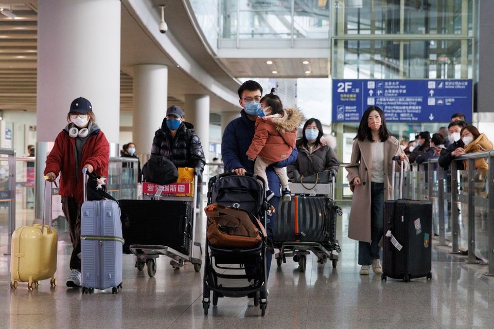 Penumpang mendorong bagasi mereka melalui aula kedatangan internasional di Bandara Internasional Ibukota Beijing setelah China mencabut persyaratan karantina penyakit virus corona (COVID-19) untuk pelancong yang datang di Beijing, China 8 Januari 2023. Foto: Reuters/Thomas Peter.
