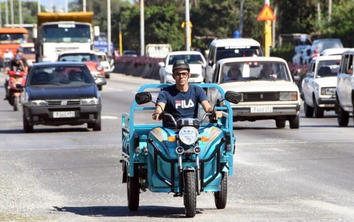 Foto yang diabadikan pada 13 Januari 2023 ini menunjukkan sebuah motor listrik roda tiga yang dirakit di pabrik perakitan perusahaan VEDCA melintas di sebuah jalan, di Havana, ibu kota Kuba. (Xinhua/Joaquin Hernandez)