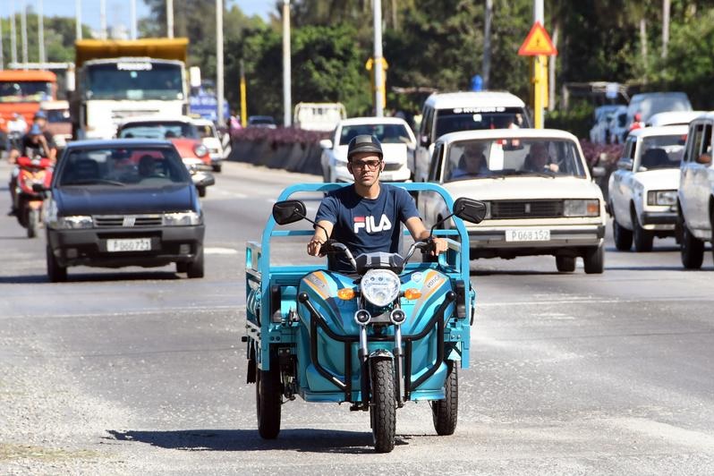 Foto yang diabadikan pada 13 Januari 2023 ini menunjukkan sebuah motor listrik roda tiga yang dirakit di pabrik perakitan perusahaan VEDCA melintas di sebuah jalan, di Havana, ibu kota Kuba. (Xinhua/Joaquin Hernandez)