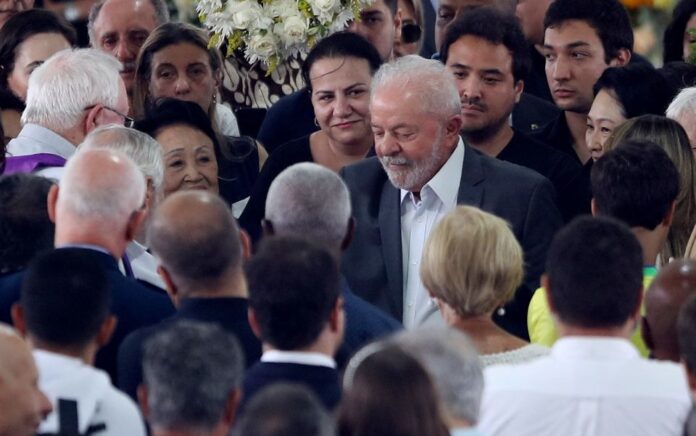 Presiden Brasil Luiz Inacio Lula da Silva bersama pelayat saat jenazah legenda sepak bola Brasil Pele disemayamkan di lapangan mantan klubnya, Stadion Santos, Vila Belmiro, pada 3 Januari 2023. Foto: Reuters/Carla Carniel.