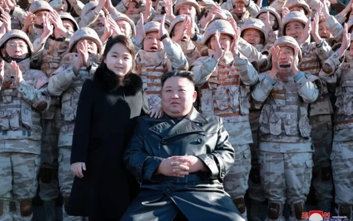 Kim Jong Un dan putrinya menghadiri sesi foto dengan para ilmuwan, insinyur, pejabat militer, dan lainnya yang terlibat dalam uji coba rudal balistik antarbenua (ICBM) Hwasong-17 baru negara itu dalam foto tak bertanggal yang dirilis pada 27 November 2022. Foto: KCNA melalui Reuters.
