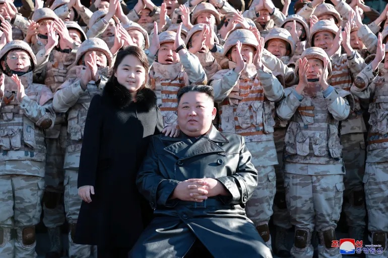 Kim Jong Un dan putrinya menghadiri sesi foto dengan para ilmuwan, insinyur, pejabat militer, dan lainnya yang terlibat dalam uji coba rudal balistik antarbenua (ICBM) Hwasong-17 baru negara itu dalam foto tak bertanggal yang dirilis pada 27 November 2022. Foto: KCNA melalui Reuters.