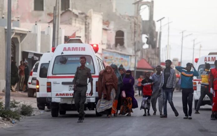 Pasukan keamanan Somalia dan warga sipil berjalan untuk melihat jenazah tersangka pejuang al Shabaab yang tewas dalam bentrokan dengan anggota keamanan di kantor walikota. Foto: Feisal Omar/Reuters.