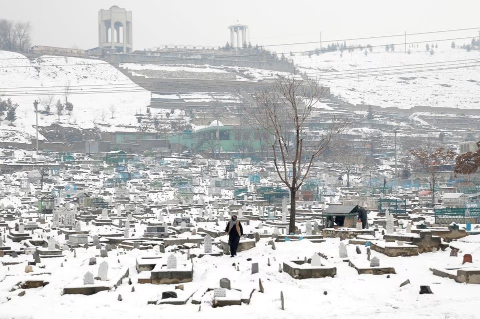 Seorang pria Afghanistan berjalan di pemakaman yang tertutup salju di Kabul, Afghanistan, 11 Januari 2023. Foto: Reuters/Ali Khara/Foto file.