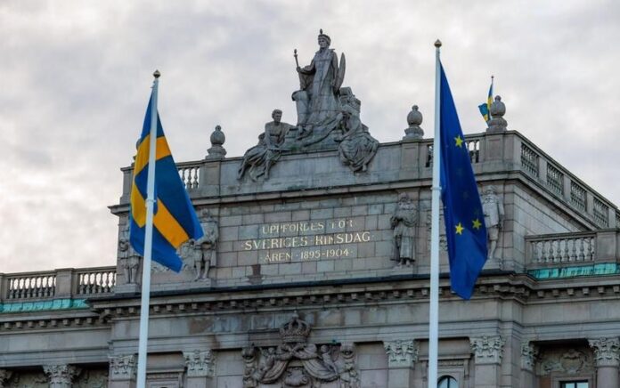 Bendera Uni Eropa (UE) dan Swedia terlihat di luar gedung Parlemen Swedia di Stockholm, Swedia, pada 1 Januari 2023. (Xinhua/Wei Xuechao)