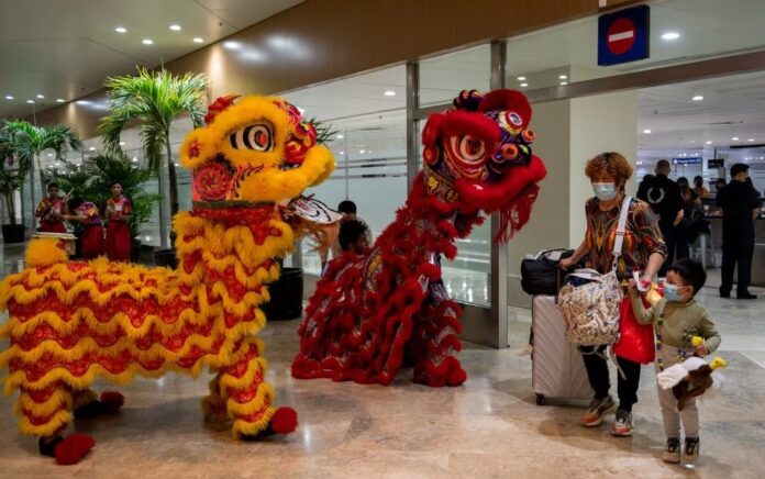 Penampil tarian naga menyapa para pelancong dari Tiongkok di Bandara Internasional Ninoy Aquino, dekat Kota Paranaque, Metro Manila, Filipina, 24 Januari 2023. Foto: Reuters/Lisa Marie David.