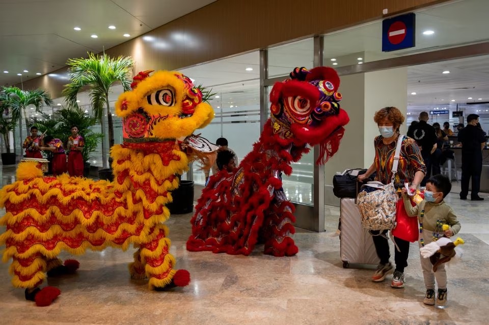 Penampil tarian naga menyapa para pelancong dari Tiongkok di Bandara Internasional Ninoy Aquino, dekat Kota Paranaque, Metro Manila, Filipina, 24 Januari 2023. Foto: Reuters/Lisa Marie David.