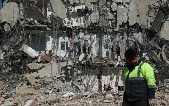 Seorang penyelamat berjalan melewati bangunan yang rusak, pasca gempa mematikan di Adiyaman, Turki 11 Februari 2023. Foto: Reuters/Sertac Kayar.