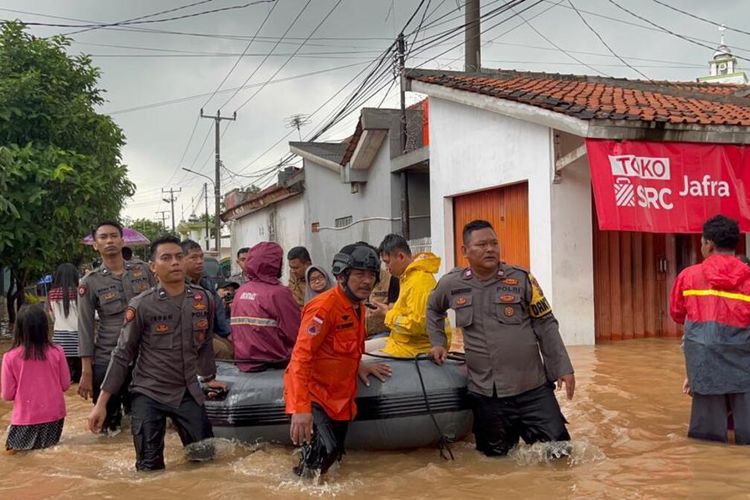 Tim evakuasi gabungan tengah mengevakuasi warga saat banjir di Perum BMI, Karawang, Jawa Barat, Senin (27/2/2023).(Dok. Polres Karawang)