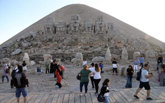 Sejumlah turis mengunjungi situs makam di puncak Gunung Nemrut di Provinsi Adiyaman, Turkiye, pada 26 September 2021. Gunung Nemrut terletak di Provinsi Adiyaman di Turkiye tenggara. Pada 1987, situs ini dicantumkan sebagai Situs Warisan Dunia UNESCO. Gunung Nemrut terkenal dengan reruntuhan situs makam yang berada di puncaknya. (Xinhua/Mustafa Kaya)