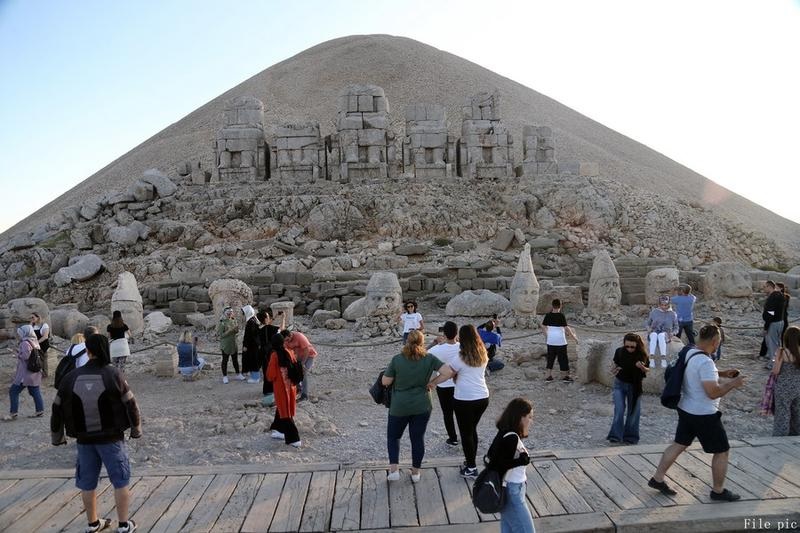 Sejumlah turis mengunjungi situs makam di puncak Gunung Nemrut di Provinsi Adiyaman, Turkiye, pada 26 September 2021. Gunung Nemrut terletak di Provinsi Adiyaman di Turkiye tenggara. Pada 1987, situs ini dicantumkan sebagai Situs Warisan Dunia UNESCO. Gunung Nemrut terkenal dengan reruntuhan situs makam yang berada di puncaknya. (Xinhua/Mustafa Kaya)