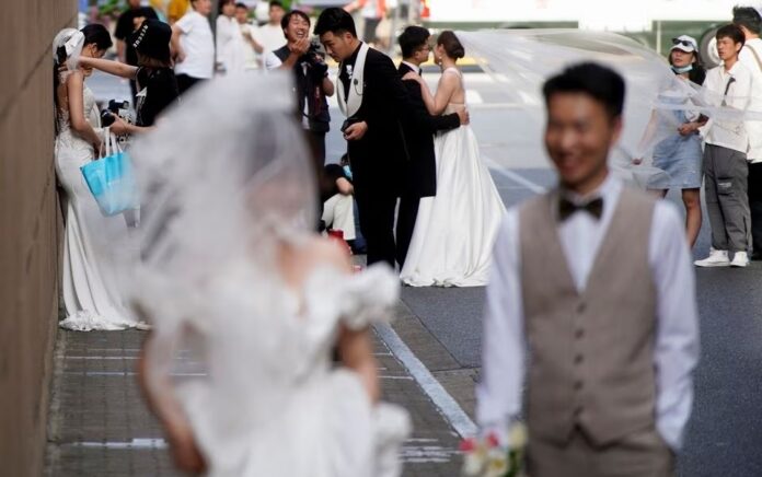 Pasangan bersiap untuk difoto saat pemotretan pernikahan di jalan, di tengah pandemi penyakit virus corona (COVID-19), di Shanghai, China, 31 Mei 2021. Foto: Reuters/Aly Song/File Foto.