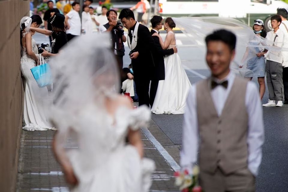 Pasangan bersiap untuk difoto saat pemotretan pernikahan di jalan, di tengah pandemi penyakit virus corona (COVID-19), di Shanghai, China, 31 Mei 2021. Foto: Reuters/Aly Song/File Foto.