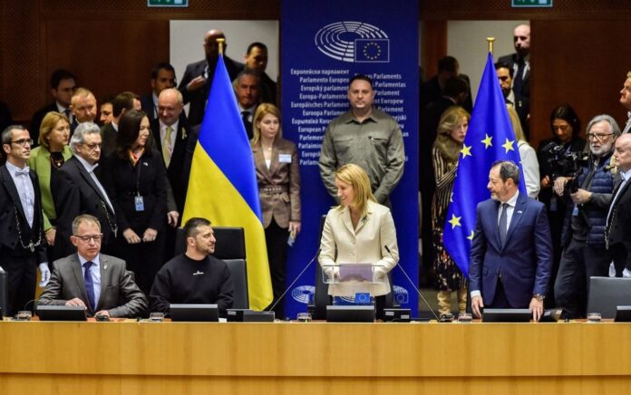 Presiden Parlemen Eropa Roberta Metsola bereaksi dengan Presiden Ukraina Volodymyr Zelenskiy di Parlemen Eropa selama pidatonya, di tengah perjalanan internasional kedua Zelenskiy sejak invasi Rusia ke Ukraina, di Brussel, Belgia 9 Februari 2023. Foto: Eric Vidal/Uni Eropa 2023/Reuters.