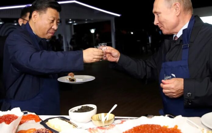 Presiden Tiongkok Xi Jinping dan Presiden Rusia Vladimir Putin bersulang selama kunjungan di Vladivostok, Rusia, pada 2018. Foto: Sergey Bobylev/TASS via Reuters.