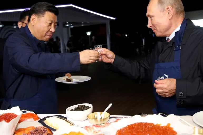 Presiden Tiongkok Xi Jinping dan Presiden Rusia Vladimir Putin bersulang selama kunjungan di Vladivostok, Rusia, pada 2018. Foto: Sergey Bobylev/TASS via Reuters.