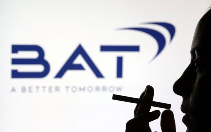 Seorang perempuan berpose dengan sebatang rokok di depan logo BAT (British American Tobacco) dalam ilustrasi yang diambil 26 Juli 2022. Foto: Reuters/Dado Ruvic.